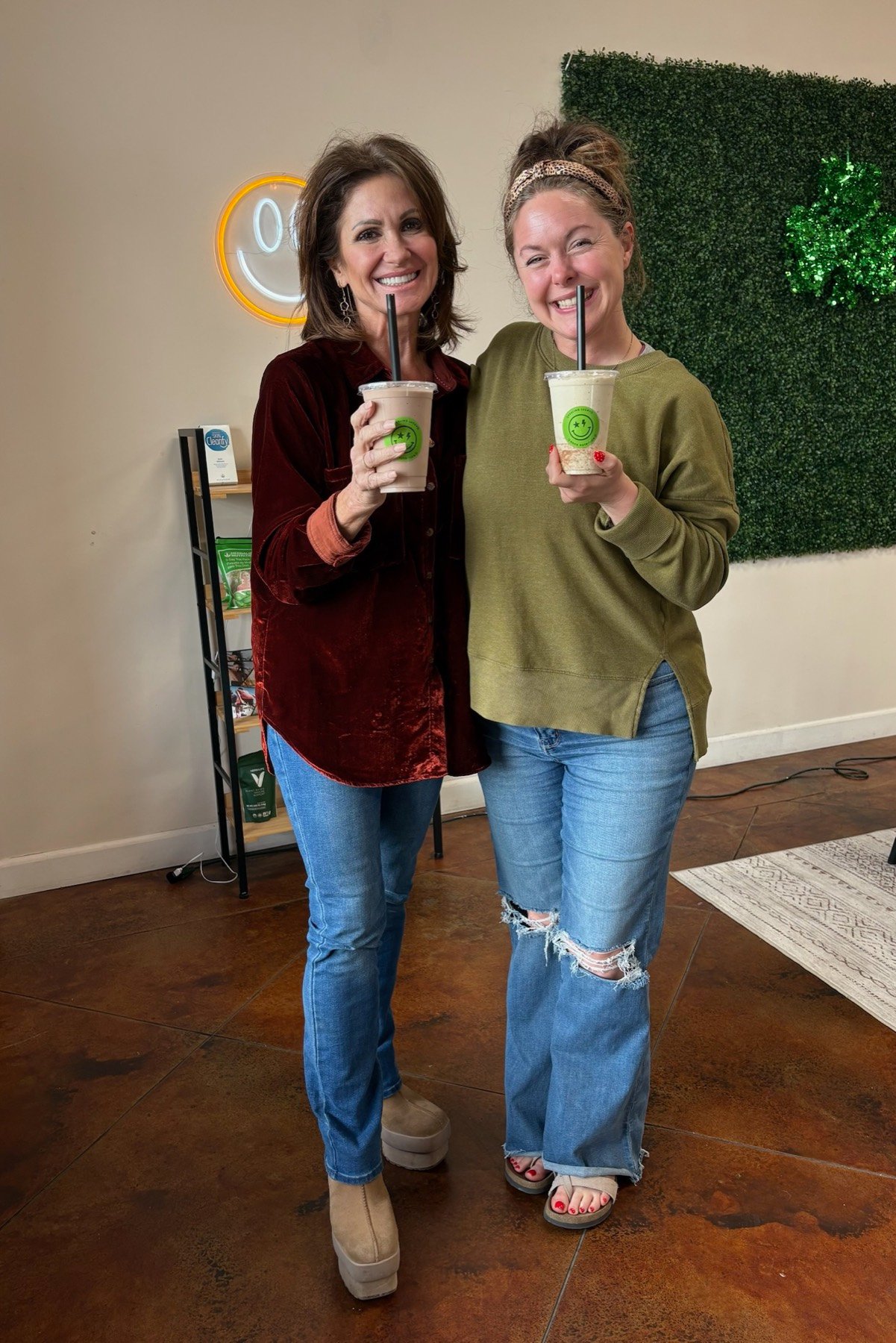 Two Rock Nutrition members laughing together over their shakes in the shop