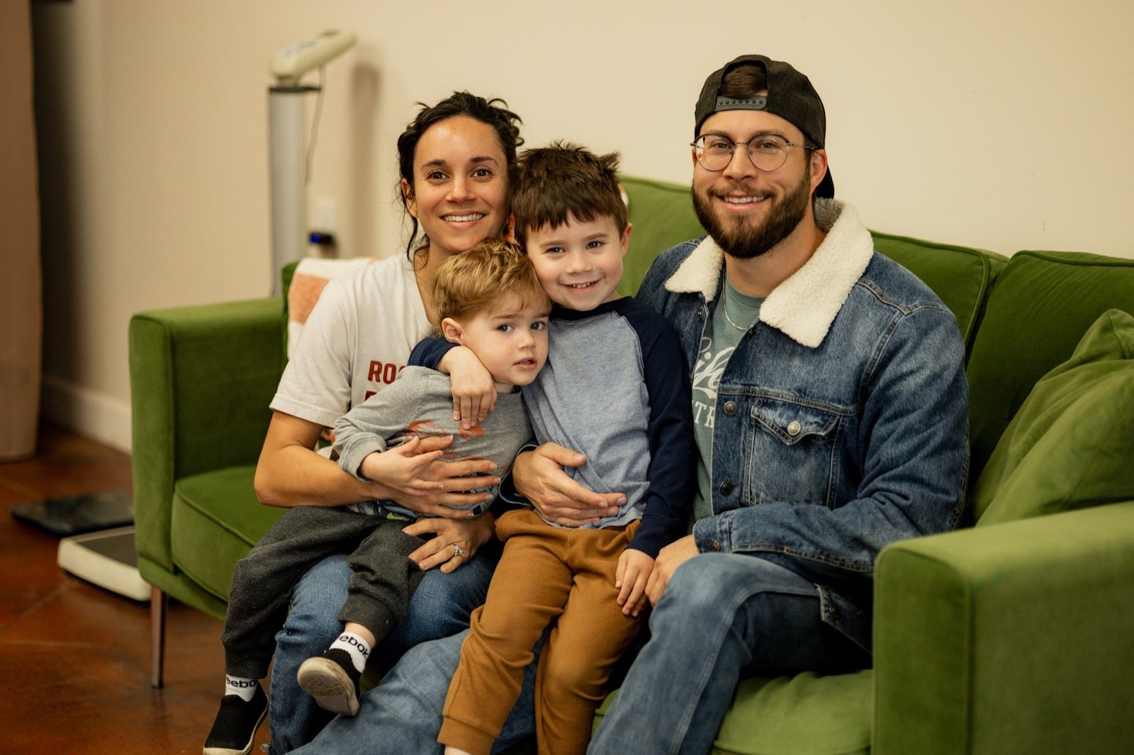 A family sitting together on the green couch inside Rock Nutrition