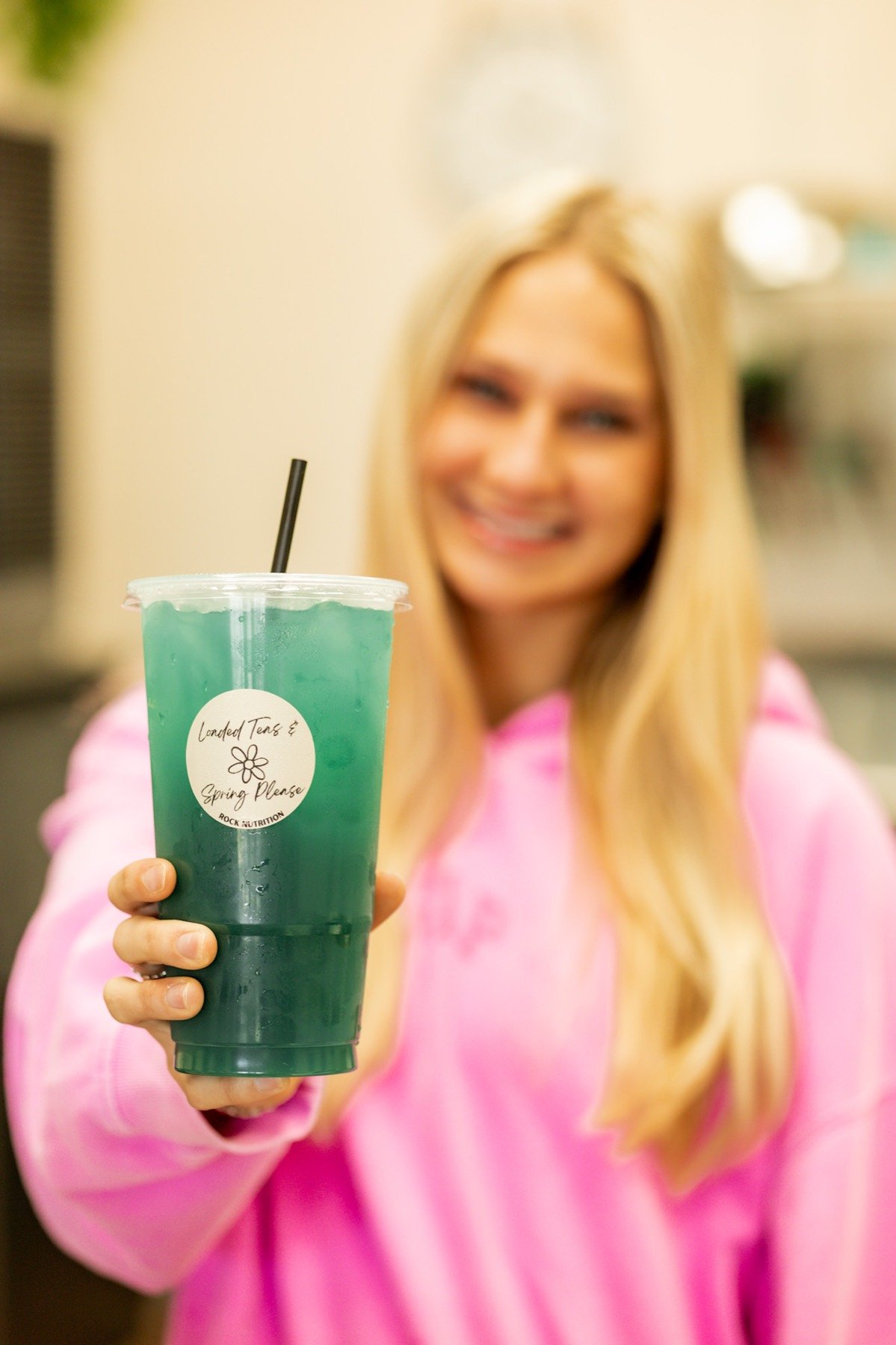 A Rock Nutrition student ambassador holding a green loaded tea